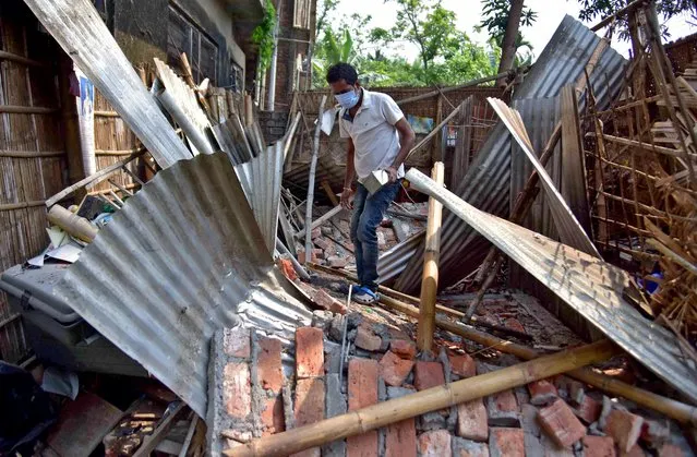 A man searches for his belongings amidst the debris after a boundary wall of his house collapsed following an earthquake in Nagaon district in the northeastern state of Assam, India, April 28, 2021. (Photo by Anuwar Hazarika/Reuters)