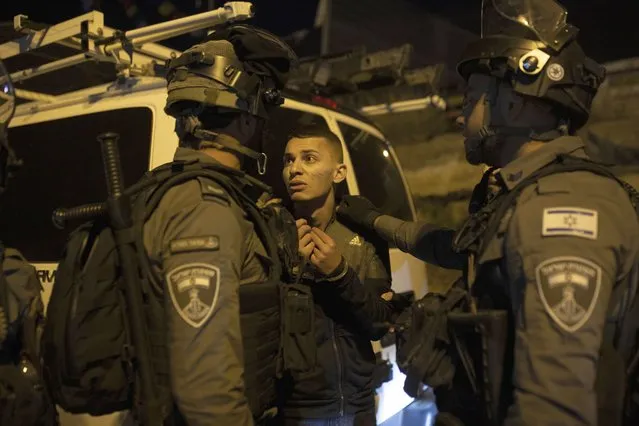 A Palestinian youth pleas with Israeli police after he was detained at a protest against the forcible eviction of Palestinian families from their homes in the Sheikh Jarrah neighborhood of Jerusalem, Thursday, May 6, 2021. Palestinians and Israeli settlers hurled rocks and chairs at each other in Sheikh Jarrah, where dozens of Palestinians are at risk of being evicted following a long legal battle with Jewish settlers trying to acquire property in the neighborhood, which is just north of Jerusalem's Old City. (Photo by Maya Alleruzzo/AP Photo)