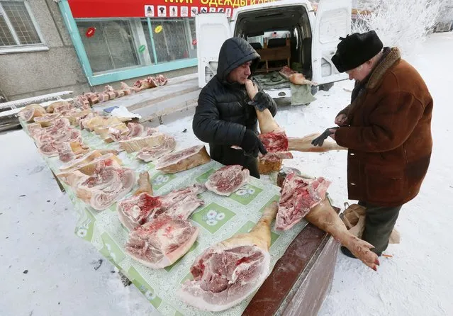 A vendor sells pork transported from a local private farm in the village of Bolshaya Murta, at a street market in Krasnoyarsk, Siberia, Russia, January 12, 2016. (Photo by Ilya Naymushin/Reuters)
