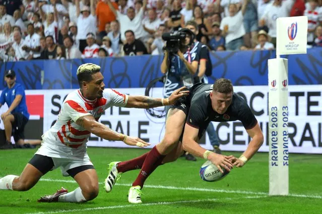 England's full-back Freddie Steward dives across the line to score a try chased by Japan's wing Lomano Lemeki (L) during the France 2023 Rugby World Cup Pool D match between England and Japan at Stade de Nice in Nice, southern France on September 17, 2023. (Photo by Nicolas Tucat/AFP Photo)