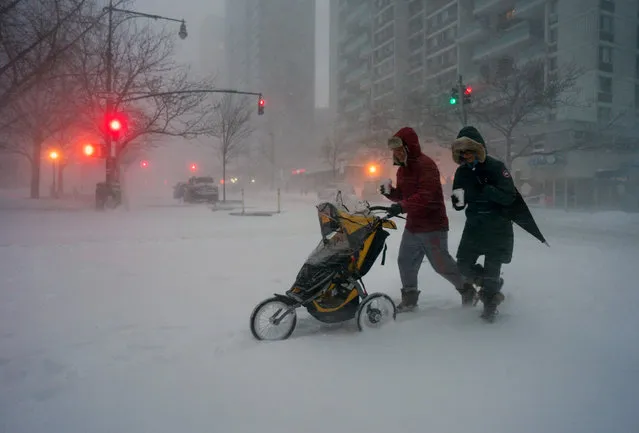 Sean Jackson and Gina Del Tatto push their child, Hayes Jackson, in a stroller as heavy snow falls in New York's Upper West Side, Saturday, January 23, 2016, as a large winter storm rolls up the East Coast. (Photo by Craig Ruttle/AP Photo)