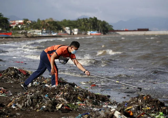 Philippine Coast Guard (PCG) personnel collect rubbish to commemorate Earth Day along a coastline in the town of Tanza, Cavite province, Philippines on 22 April 2021. Earth Day, also known as “International Mother Earth Day” as proclaimed by the United Nations in 2009, is observed around the world on 22 April annually in order to raise awareness and appreciation for the earth's environment. The theme of this year's earth day is “Restore Our Earth” and will be marked by events taking place virtually due to the COVID-19 restrictions around the world. (Photo by Francis R. Malasig/EPA/EFE)