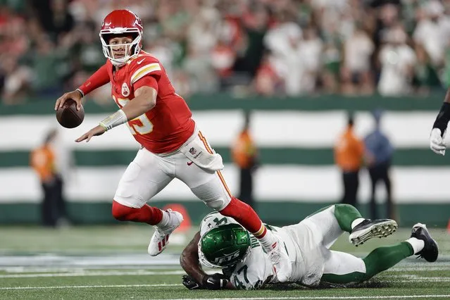 Kansas City Chiefs quarterback Patrick Mahomes (15) is tripped up by New York Jets linebacker Bryce Huff (47) as he throws during the second quarter of an NFL football game, Sunday, October 1, 2023, in East Rutherford, N.J. (Photo by Adam Hunger/AP Photo)
