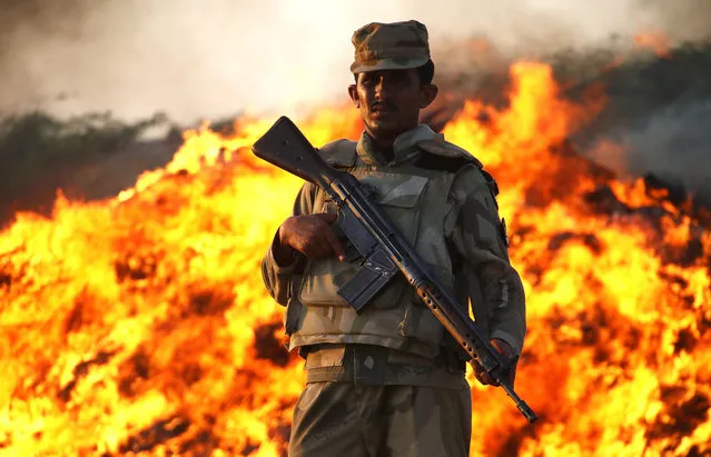 A member of the Pakistani security forces stands guard during the incineration of seized illegal drugs, in Karachi, Pakistan, October 15, 2015. (Photo by Shahzaib Akber/EPA)