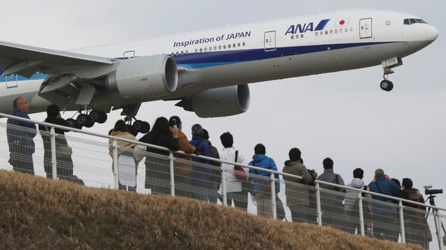 People watch an All Nippon Airways' plane approach the Narita International Airport from a popular viewing spot at Sakuranoyama Park in Narita, east of Tokyo, March 14, 2015. (Photo by Koji Sasahara/AP Photo)