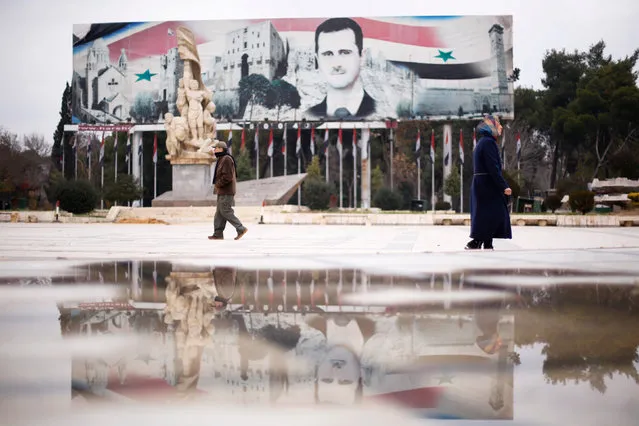 People walk past a billboard depicting Syria's President Bashar al-Assad at Saadallah al-Jabri Square, in the government controlled area of Aleppo, Syria December 17, 2016. (Photo by Omar Sanadiki/Reuters)