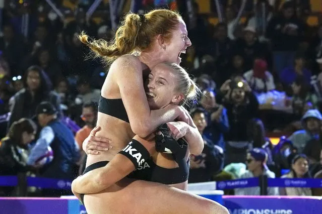 Kelly Cheng, top, and Sara Hughes, of the United States, celebrate after beating compatriots Kristen Nuss and Taryn Kloth during a women's Beach Volleyball World Cup semifinal match in Tlaxcala, Mexico, Saturday, October 14, 2023. (Photo by Fernando Llano/AP Photo)
