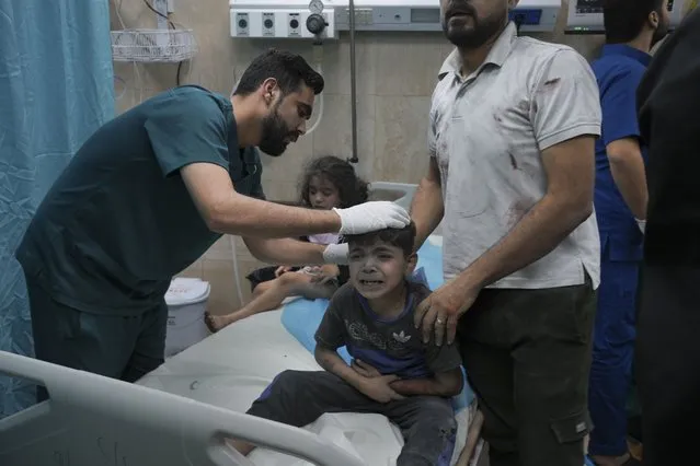 A Palestinian boy, wounded in Israeli bombardment on Gaza Strip, cries in a hospital in Deir al-Balah, south of the Gaza Strip, Saturday, October 21, 2023. (Photo by Hatem Moussa/AP Photo)