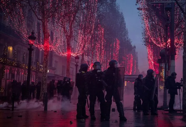 Police guard a side street during the “yellow vests” demonstration on the Champs-Elysées near the Arc de Triomphe on December 8, 2018 in Paris France. “Yellow Vests” (“Gilet Jaunes” or “Vestes Jaunes”) is a protest movement without political affiliation which was inspired by opposition to a new fuel tax. After a month of protests, which have wrecked parts of Paris and other French cities, there are fears the movement has been infiltrated by “ultra-violent” protesters. Today's protest has involved at least 5,000 demonstrators gathering in the Parisian city centre with police having made over 200 arrests so far. (Photo by Chris McGrath/Getty Images)