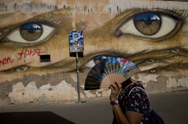 A woman walks past the a mural by British street artist My Dog Sighs in Rome's Trastevere neighborhood, Monday, September 24, 2018. (Photo by Alessandra Tarantino/AP Photo)