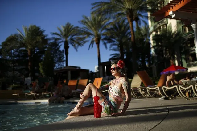 In this April 4, 2015, photo, a woman who goes by Martha War sits by the pool during the Viva Las Vegas Rockabilly Weekend in Las Vegas. Thousands of rockabilly fans attended the 18-year-old even. (Photo by John Locher/AP Photo)