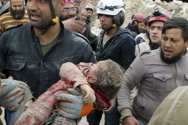 Civil defence members carry a dead child after what activists said was shelling by warplanes loyal to Syria's president Bashar Al-Assad in Aleppo's rebel-controlled Bab Al-Nairab district April 12, 2015. (Photo by Abdalrhman Ismail/Reuters)