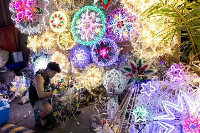 A vendor works on a Christmas star lantern, locally known as parol, at a street market in Quezon City, Metro Manila, Philippines on November 29, 2023. (Photo by Eloisa Lopez/Reuters)