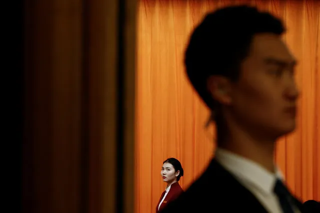 A security officer and an attendant keep watch at an entrance to the plenum of the National People's Congress (NPC) at the Great Hall of the People in Beijing, China, March 5, 2019. (Photo by Thomas Peter/Reuters)