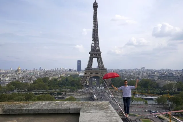 French slackliner Nathan Paulin performs on the second time on a 70-meter-high slackline between the Eiffel Tower and the Chaillot Theater across the Seine River, in Paris Sunday, September 19, 2021. (Photo by Francois Mori/AP Photo)