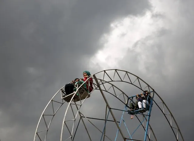 Children ride on a ferris wheel during  the celebration for Afghan New Year (Newroz) in Kabul, Afghanistan March 20, 2016. (Photo by Ahmad Masood/Reuters)