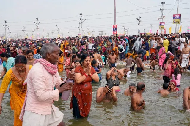 Hindu devotees pray as they take a holy dip at the Sangam, the confluence of three rivers – the Ganges, the Yamuna and the mythical Saraswati, on Maghi Purnima or the full-moon day at the annual traditional fair in Prayagraj, in the northern Indian state of Uttar Pradesh, India, Saturday, February 24, 2024. (Photo by Rajesh Kumar Singh/AP Photo)