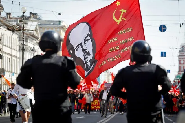 Communist party supporters carry a flag depicting Soviet Union founder Lenin during a May Day rally in St.Petersburg, Russia, Wednesday, May 1, 2019. (Photo by Dmitri Lovetsky/AP Photo)