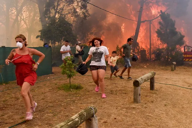 People run from flames during fire in La Floresta, Uruguay, 26 January 2023. The fire grew due to intense winds amid drought conditions and has resulted in several casualties. (Photo by Federico Gutierrez/EPA/EFE)