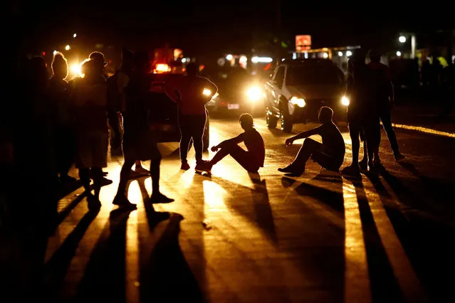 Migrants block a street during a protest requesting that Mexican authorities issue humanitarian visas for migrants to be able to cross the Mexican territory, while taking part in a caravan heading to the U.S. border in Huehuetan, Mexico on November 29, 2021. (Photo by Jose Luis Gonzalez/Reuters)