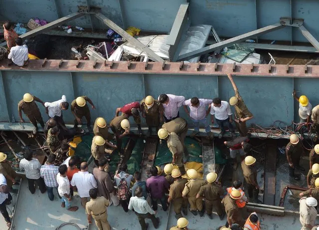 Indian rescue workers and volunteers search for people trapped under the wreckage of a collapsed flyover bridge in Kolkata on March 31, 2016. At least 14 people were killed and dozens more injured when a flyover collapsed in a busy Indian city on March 31, an official said, as emergency workers battled to rescue people trapped under the rubble. (Photo by Dibyangshu Sarkar/AFP Photo)