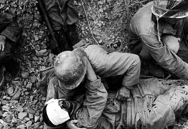 A soldier from the US 7th Army Division comforts a wounded comrade during the fight for Okinawa, Japan, May 1945. (Photo by W. Eugene Smith/The LIFE Picture Collection/Getty Images)
