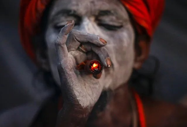 A sadhu, or holy man, smokes marijuana from a clay pipe at the Pashupati Temple in Kathmandu, Nepal, 24 February 2017, during celebrations marking the Hindu festival of Maha Shivaratri. (Photo by Narendra Shrestha/EPA)