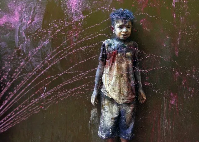 A boy smeared with colour reacts as other boys rub coloured powder on his head and face during Holi celebrations in the southern Indian city of Chennai March 16, 2014. Holi, also known as the Festival of Colours, heralds the beginning of spring and is celebrated all over India. (Photo by Reuters)