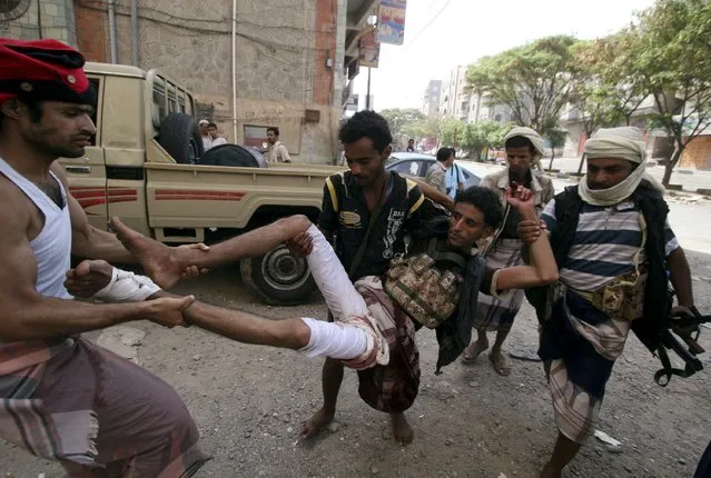 Fighters of the Popular Resistance Committees rush a comrade to a hospital after he was injured during clashes with Houthi fighters in Yemen's southwestern city of Taiz May 15, 2015. (Photo by Reuters/Stringer)