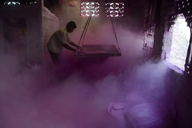 An Indian labourer sifts coloured powder, known as “gulal”, to be used during the forthcoming spring festival of Holi, inside a factory at Fulbari village on the outskirts of Siliguri on March 6, 2017. Holi, the popular Hindu spring festival of colours is observed in India at the end of the winter season on the last full moon of the lunar month, and will be celebrated on March 13 this year. (Photo by Diptendu Dutta/AFP Photo)