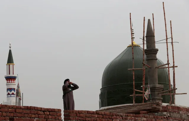 A muezzin issues his call to prayer on a roof of the Mumtaz Qadri shrine outside Islamabad, Pakistan February 27,  2017. (Photo by Caren Firouz/Reuters)