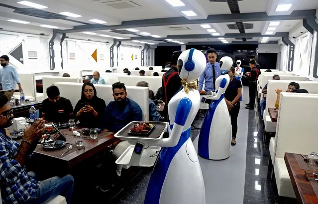 Robots serve trays with food to customers waiting at the Robot theme restaurant in Bangalore, India, 17 August 2019. Six robots are deployed as waiters at the the robot-themed Robot restaurant where each table is equipped with a tablet to place one's order. (Photo by Jagadeesh N.V./EPA/EFE)