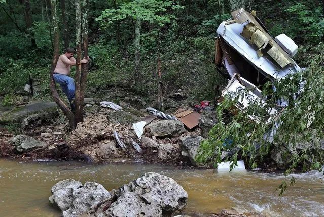 Rollie Leonberger, 50, shows where he said he found a woman in Jefferson County, Mo., Thursday, July 2, 2015. The creek had flooded and swept the woman's car off the road. Leonberger found her several hundred yards downstream. “I don't know how I heard her screaming over the noise of the flood and the rain”, said Leonberger. ”The water was up over her waist when I found her”, he said. (Photo by J. B. Forbes/St. Louis Post-Dispatch via AP Photo)
