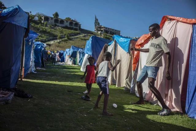 Children play at the Devirel camp in Les Cayes, Haiti, Wednesday, February 16, 2022. Thousands of Haitians who lost their homes in the quake remain in camps, living in cramped shelters made of plastic and cloth sheets and corrugated metal. (Photo by Joseph Odelyn/AP Photo)