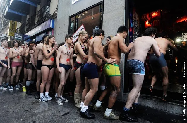 Semi-nude shoppers queue for free clothes during a promotion by a Spanish clothes outlet on January in Madrid