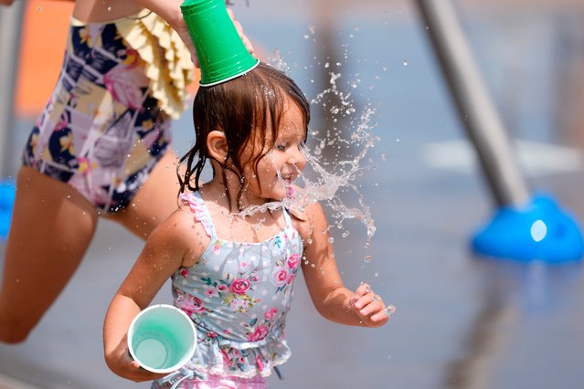 Nora White, 6, dumps a cup of water on her sister Kennedy White, 3, at Barnett Field Splash Pad in Edmond, Okla., on Tuesday, June 25, 2024.(Photo by Bryan Terry/The Oklahoman via USA TODAY Network)