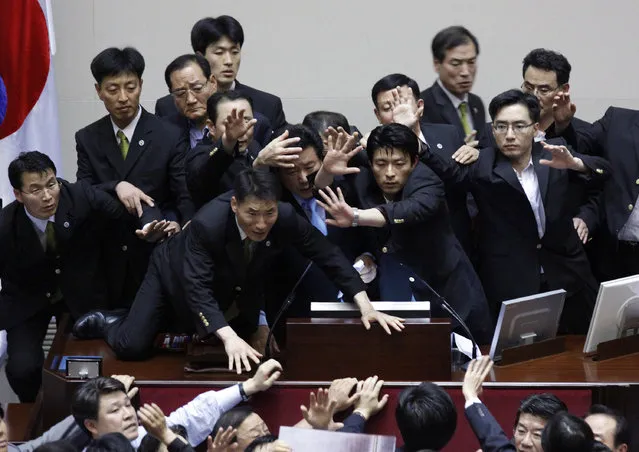 Lee Yoon-sung (C), vice speaker of the National Assembly and a lawmaker of the ruling Grand National Party, is surrounded by security guards as he passes new bills at the National Assembly main chamber in Seoul, July 22, 2009. (Photo by Jo Yong-Hak/Reuters)