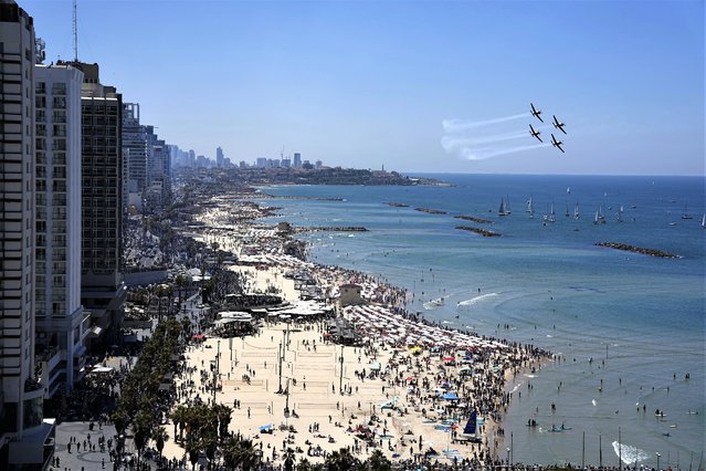 Israeli fighter jets perform in an air show marking the country's 75th Independence Day over sailboats in the Mediterranean Sea in Tel Aviv, Israel, Wednesday, April 26, 2023. (Photo by Ariel Schalit/AP Photo)