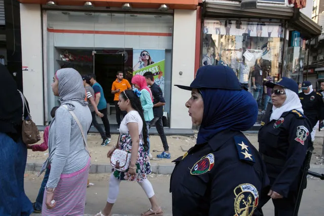 Egyptian policewomen who are part of a new anti-harassment force, escort young women in Cairo on the first day of Eid Al-Fitr,  Friday, July 17, 2015. (Photo by Roger Anis/AP Photo)