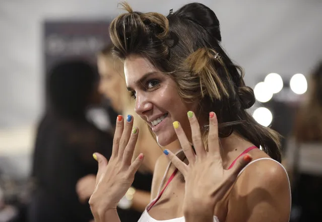 Model Valentina Ferrer, of Argentina, shows off her nails as she has her hair and make-up done before the Robb & Lulu swimwear show as part of Funkshion Fashion Week Swim, Friday, July 17, 2015, in Coral Gables, Fla. Ferrer was Miss Universe Argentina in 2014. (Photo by Lynne Sladky/AP Photo)