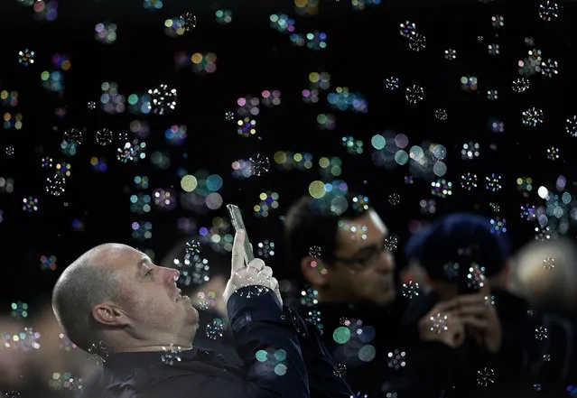 A West Ham supporter photographs bubbles with his mobile phone prior to the English Premier League soccer match between West Ham United and Southampton at Boleyn Ground stadium in London, Monday, December 28, 2015. (Photo by Frank Augstein/AP Photo)