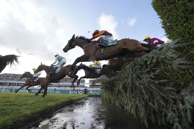 Noble Yeats ridden by Sam Waley-Cohen at centre, clears the water jump on the way to winning Grand National horse race at Aintree, Liverpool, England, Saturday, April 9, 2022. The iconic Grand National race which is run over fences is 4 miles, 2 ½ furlongs has its origins in the 1839 Grand Liverpool Steeplechase. (Photo by Jon Super/AP Photo)