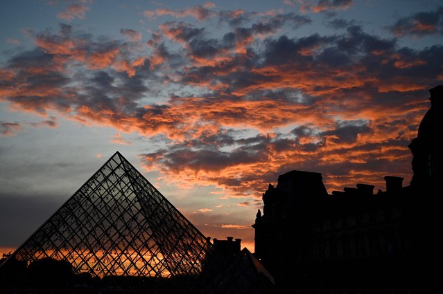 This photograph shows the Louvre Pyramid at sunset, designed by Chinese-US architect Ieoh Ming Pei and a wing of the Louvre museum in Paris on June 19, 2024. (Photo by Christophe Delattre/AFP Photo)