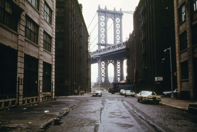 The Manhattan Bridge, framed by nearby buildings, photographed in Brooklyn in June 1974. (Photo by Danny Lyon/NARA)