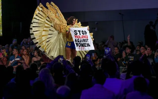 Miss Brazil Julia Horta pulls out a flag that reads “Stop violence against women” while walking in her costume during the Miss Universe 2019 preliminary round in Atlanta, Georgia, USA, 06 December 2019. The final stages of the competition will take place on 08 December 2019 in Atlanta. (Photo by Branden Camp/EPA/EFE/Rex Features/Shutterstock)