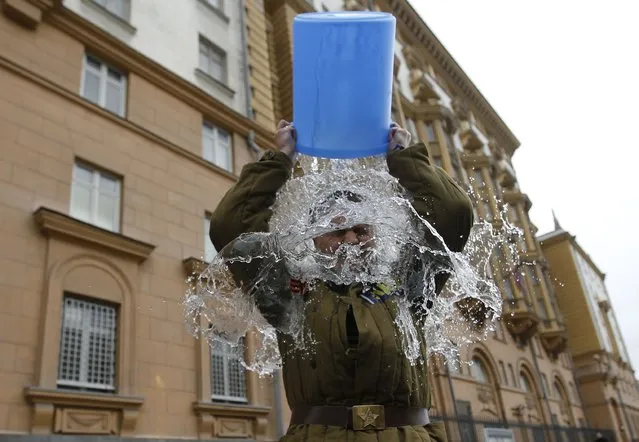 Alexei Didenko, a deputy for the Russian State Duma, dumps a bucket of cold water on himself in front of the American embassy in Moscow, September 3, 2014. Didenko said he was performing the ice bucket challenge not only to raise awareness for ALS (Amyotrophic Lateral Sclerosis) research, but also to protest against new U.S. Ambassador to Russia John Tefft, and what Didenko calls “anti-Russian American propaganda”. (Photo by Maxim Zmeyev/Reuters)
