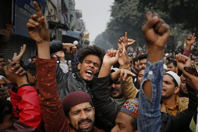 Indians shout slogans in front of a police barricade to protest against the Citizenship Amendment Act in New Delhi, India, Friday, December 20, 2019. (Photo by Altaf Qadri/AP Photo)