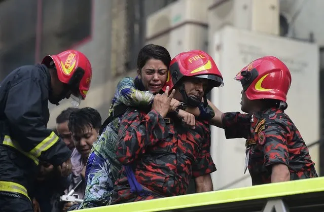 A Bangladeshi survivor reacts after being rescued by firefighters from a burning office building in Dhaka on March 28, 2019. A huge fire tore through a Dhaka office block March 28 killing at least five people with many others feared trapped in the latest major inferno to hit the Bangladesh capital. (Photo by Munir Uz Zaman/AFP Photo)