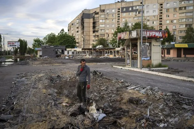 A man searches for metal scraps in a shelled neighbourhood in Kharkiv, eastern Ukraine, Thursday, May 19, 2022. (Photo by Bernat Armangue/AP Photo)