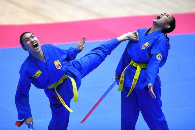 Cambodia's Pov Sokha and Soeur Chanleakhena compete in the female pair sword form category of the vovinam event during the 31st Southeast Asian Games (SEA Games) in Hanoi on May 19, 2022. (Photo by Nhac Nguyen/AFP Photo)